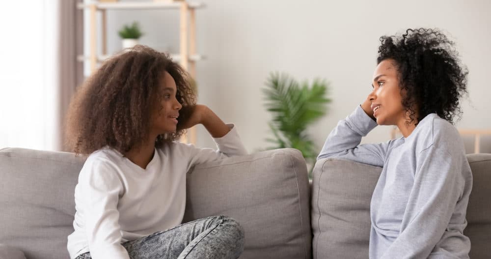 Teenage girl talking to her parent about mental health